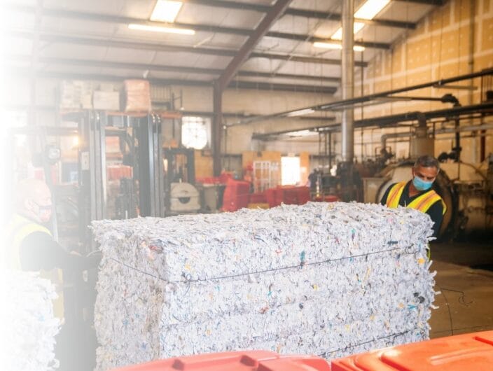 Bales of securely shredded paper baled for recycling