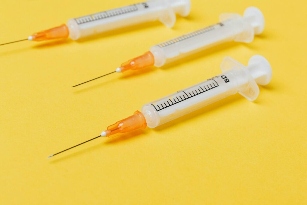Three syringes on yellow background