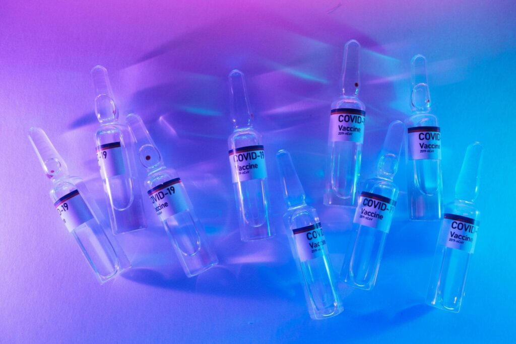 COVID-19 vaccine vials with purple lighting