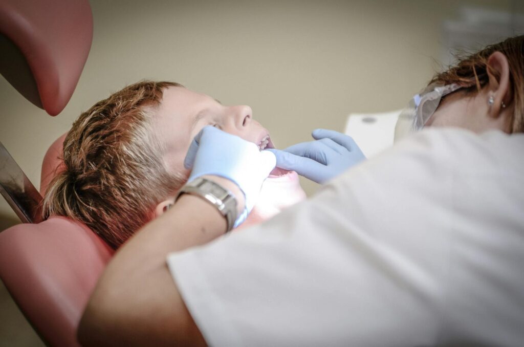 Dentist examining child's teeth in clinic.