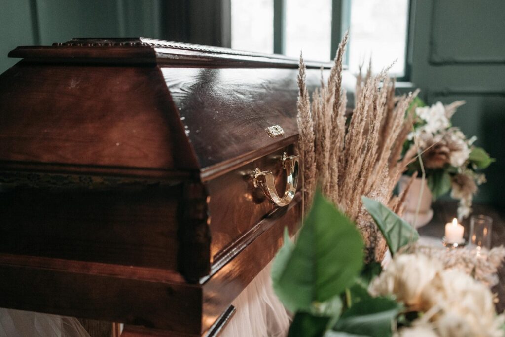 Wooden casket with decorative flowers nearby