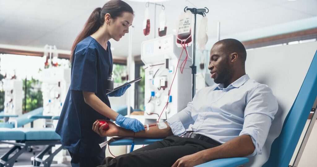 Nurse assisting patient in blood donation process.
