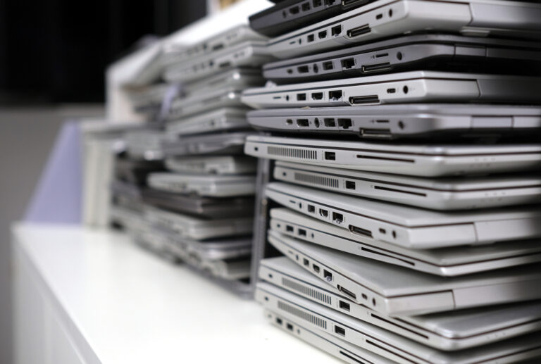 Rack with a stack of laptops in the storage room of a company waiting for e-waste shredding